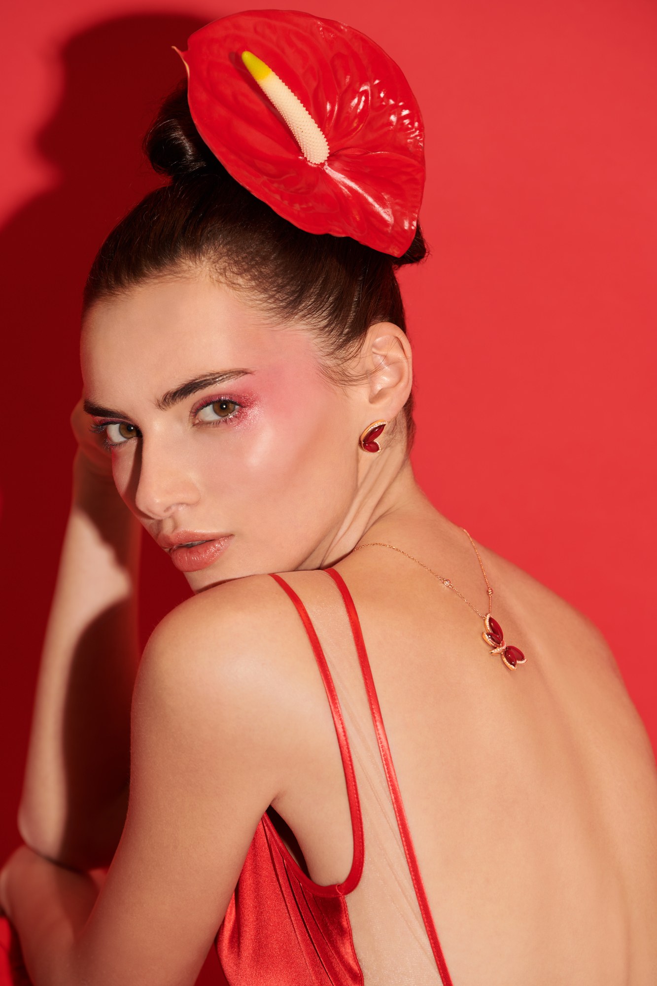 Modella di schiena con anthurium rosso e gioielli, Falcinelli
