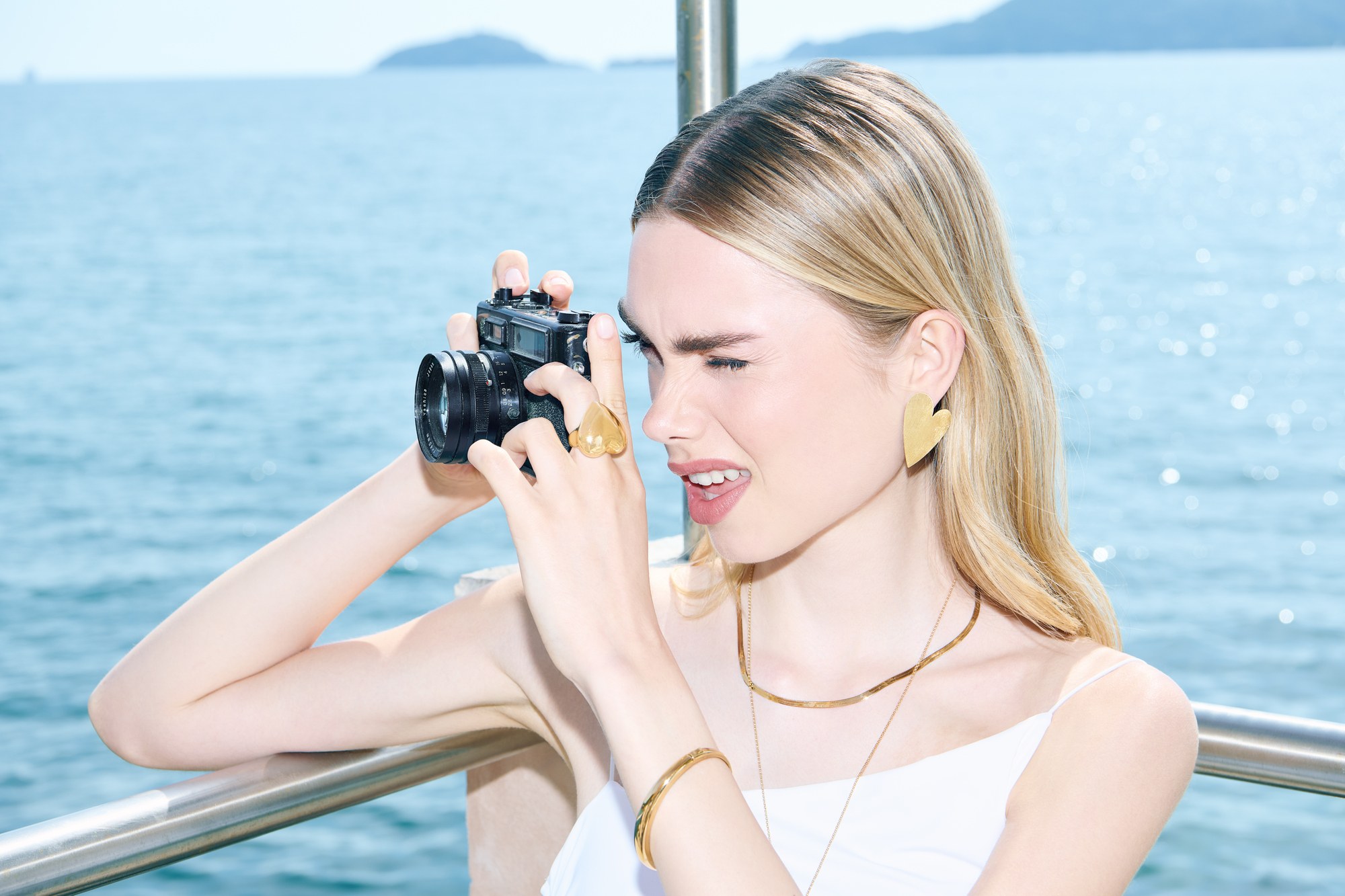 Ragazza che fotografa in barca con gioielli d'oro a Lerici
