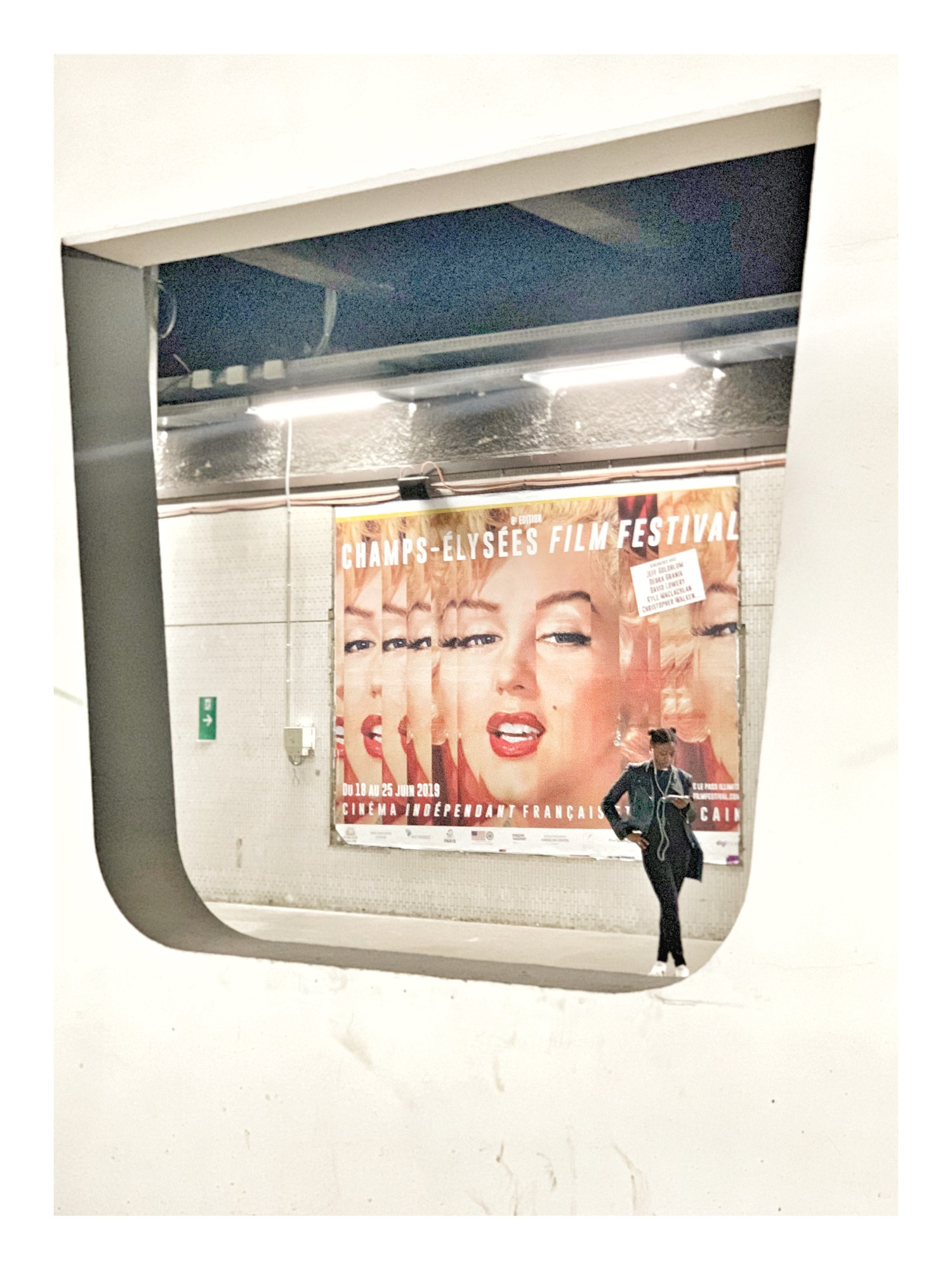 Finestrino di un treno con manifesto di Marilyn Monroe e un passante