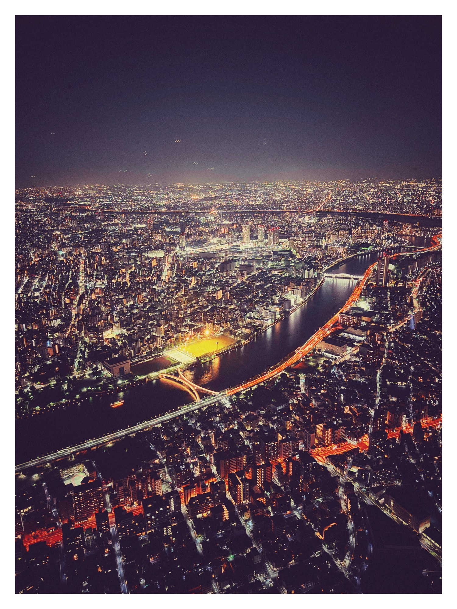 Vista aerea notturna di una città con il fiume illuminato