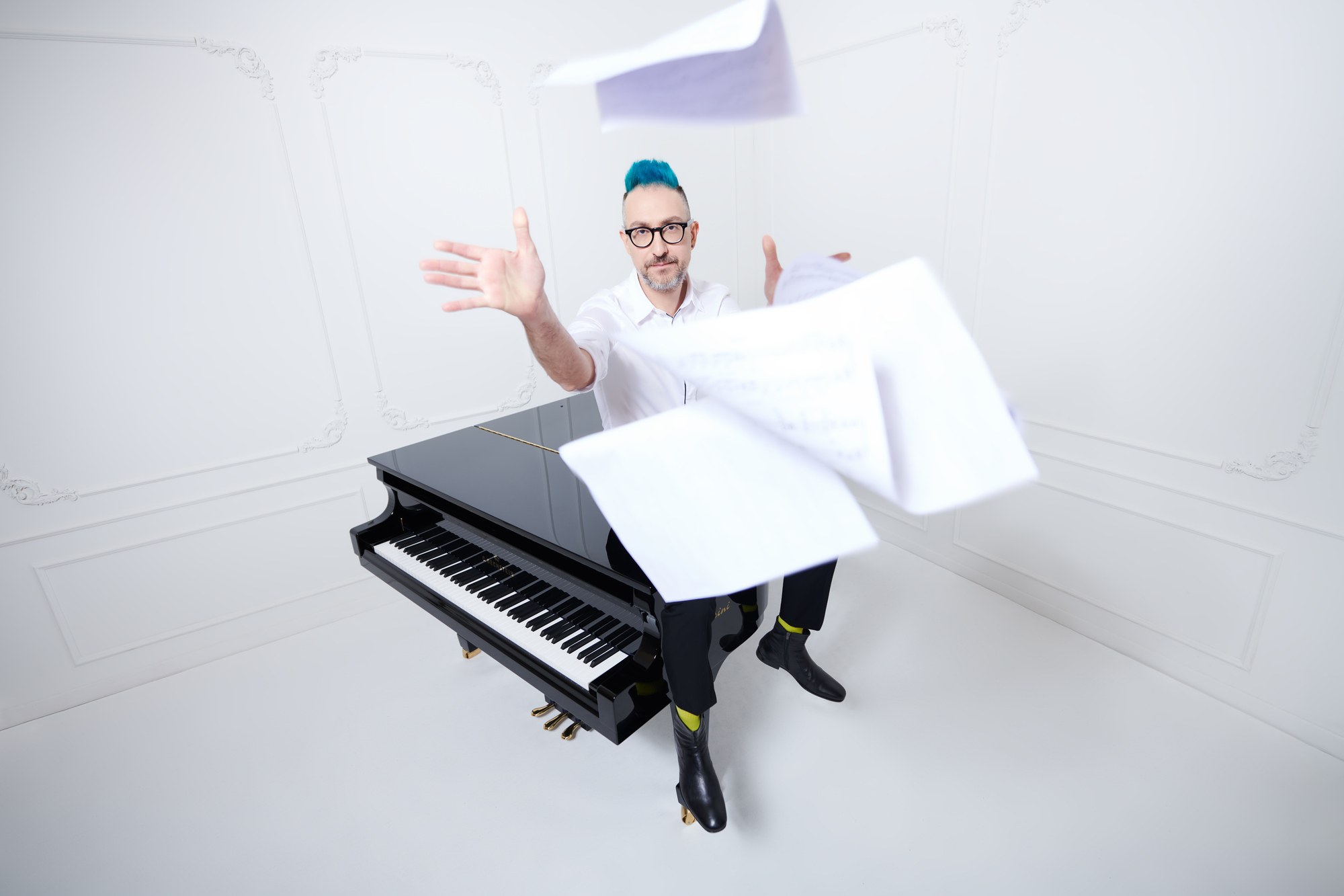 Pianista al pianoforte con gli spartiti in volo