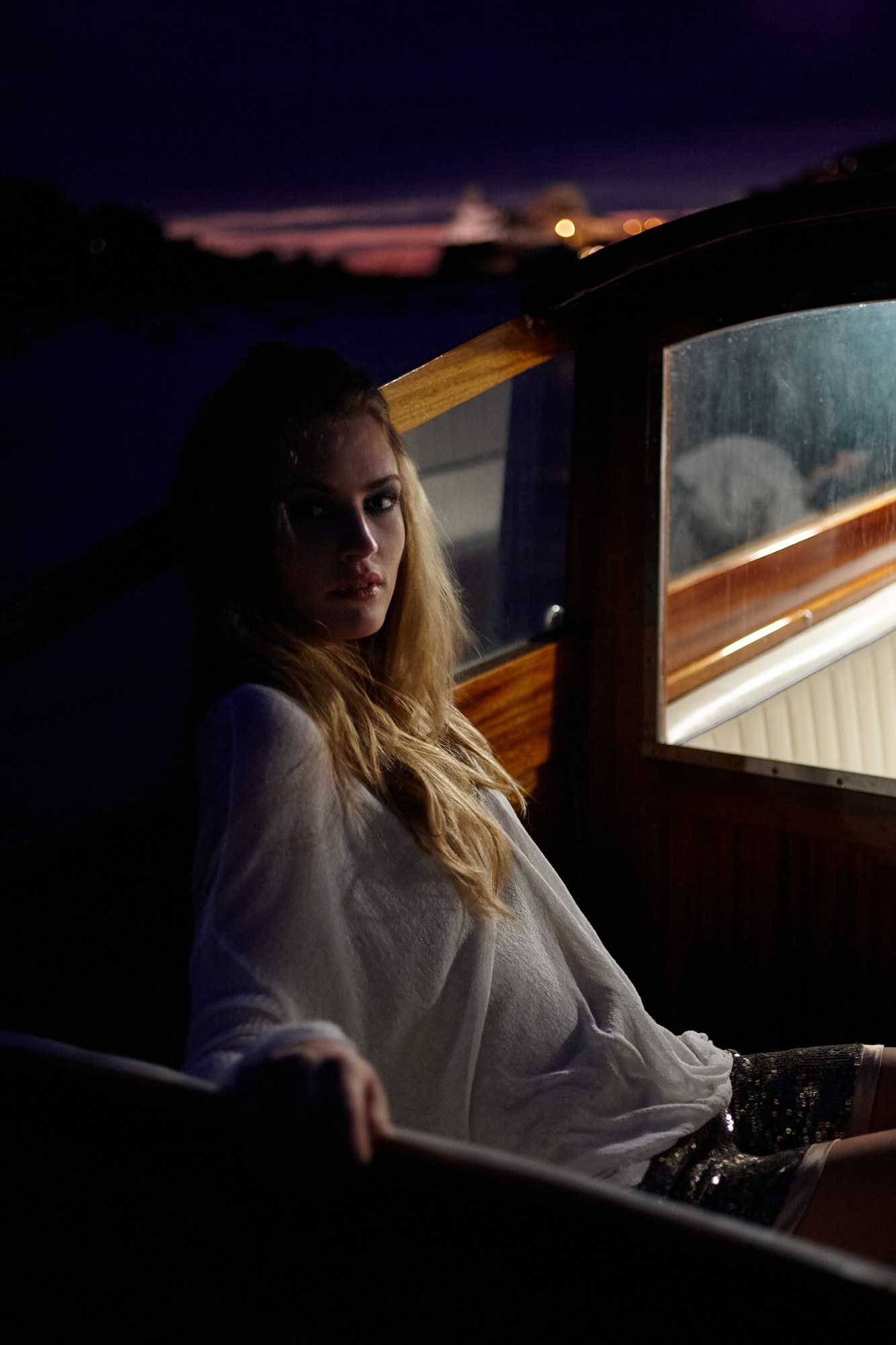 Donna su una barca al tramonto con luce blu