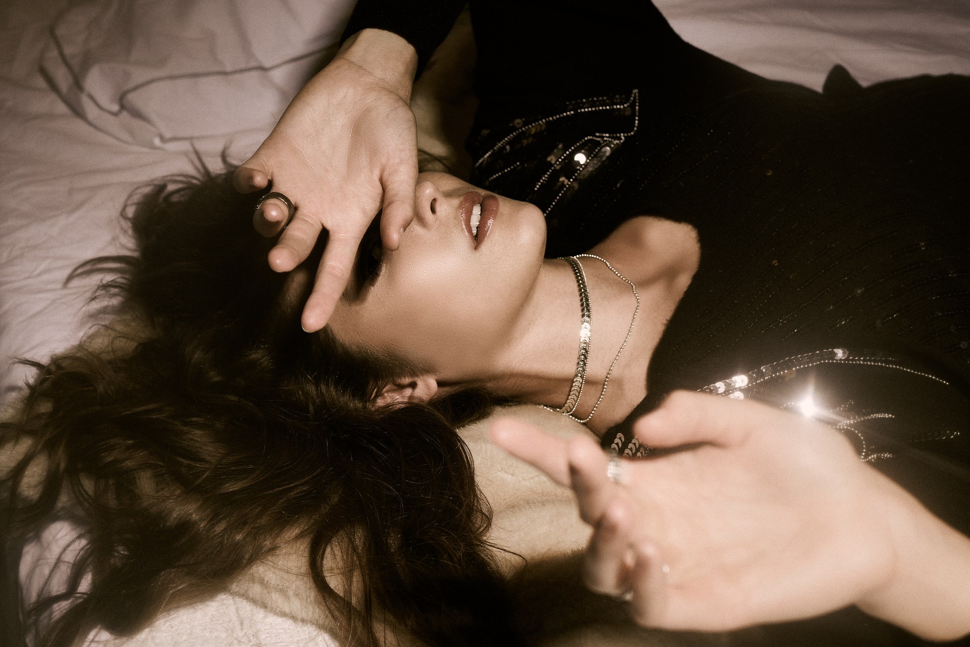 Ritratto di donna sdraiata con le mani sul viso