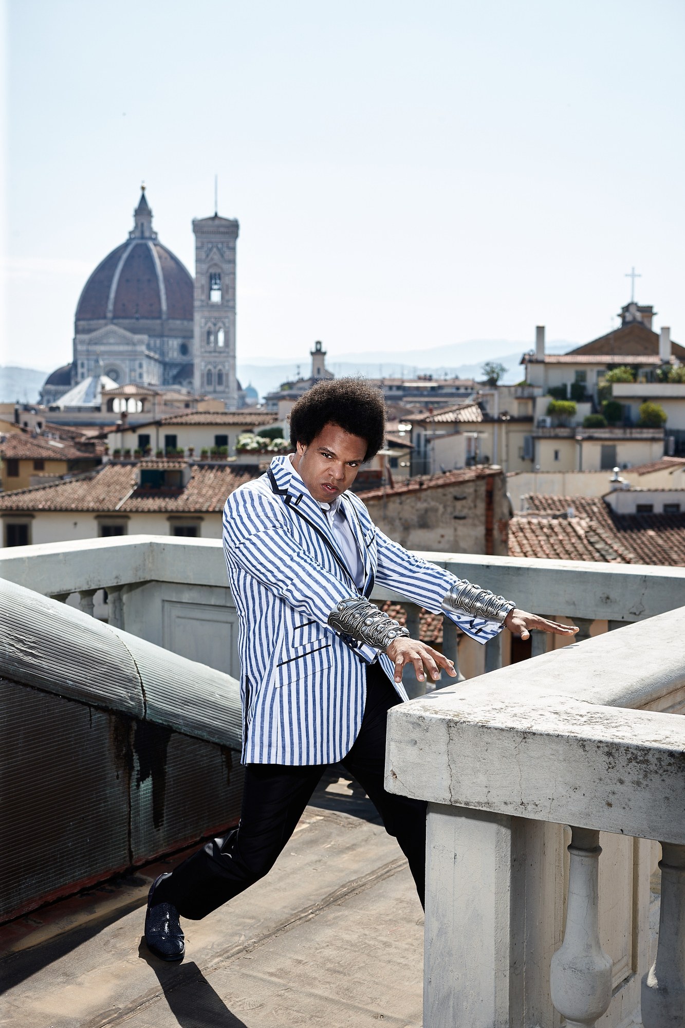 Uomo in giacca a righe su una terrazza con il Duomo di Firenze