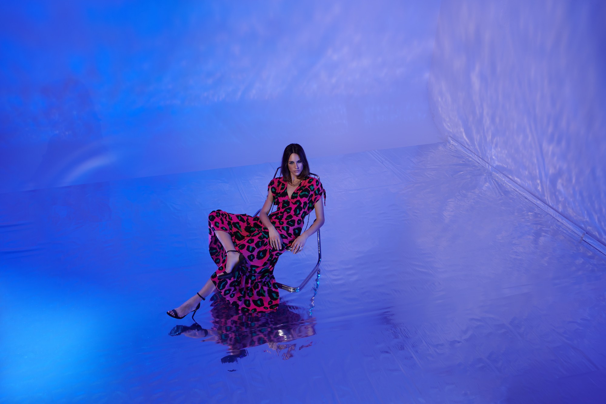 Modella seduta in un ambiente completamente blu