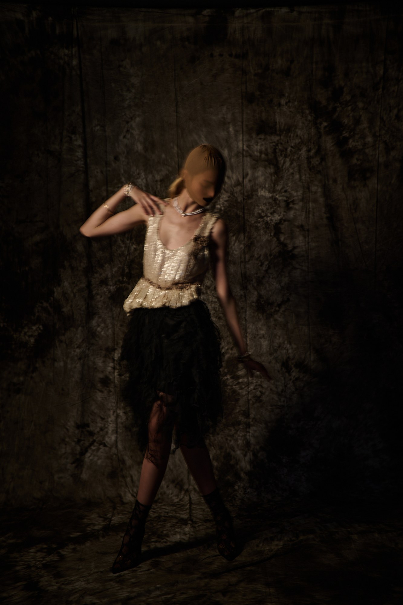 Modella con corsetto in un ambiente scuro e teatrale