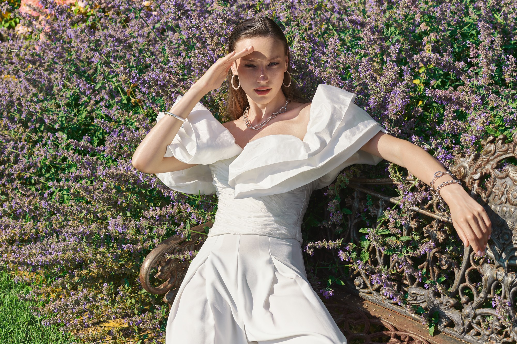 Modella in abito bianco con volant tra la lavanda in fiore