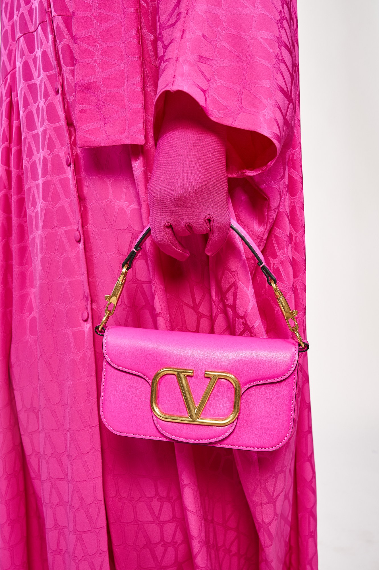 Borsa rosa con fibbia dorata su abito fucsia