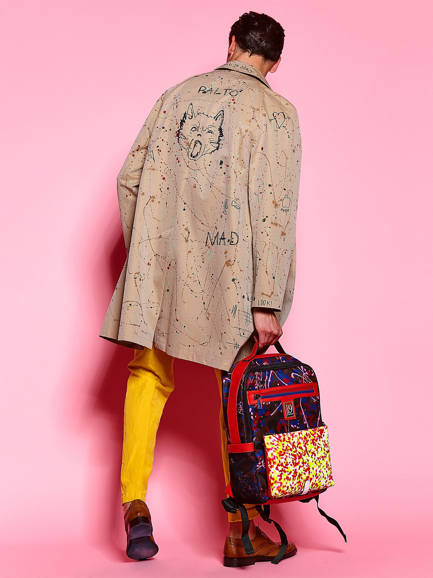 Modello di spalle con giacca dipinta e zaino colorato su fondo rosa, Pitti Uomo