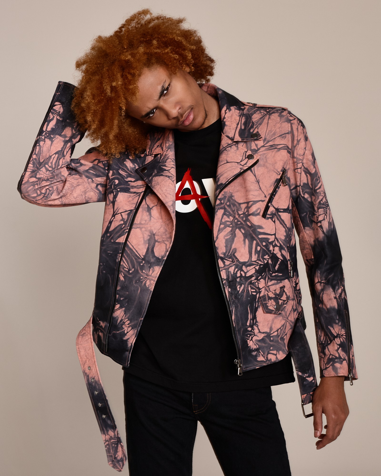 Modello con capelli ricci ramati e giacca biker tie-dye rosa