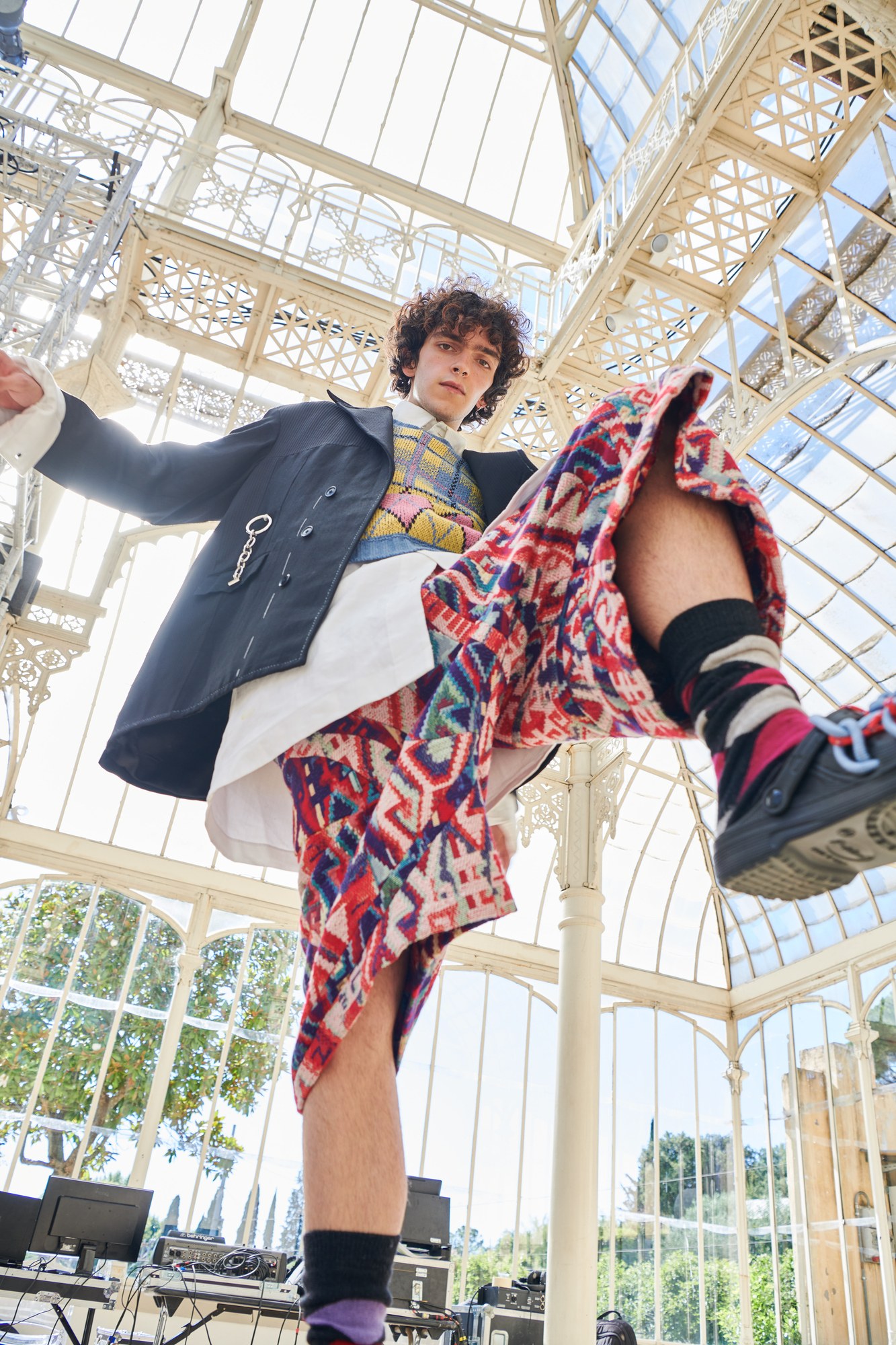 Modello in movimento con cappotto e pantaloni stampati in una serra