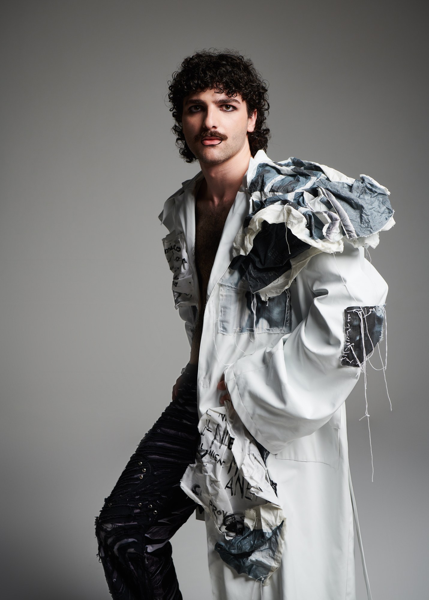 Modello con baffi e cappotto bianco scultoreo