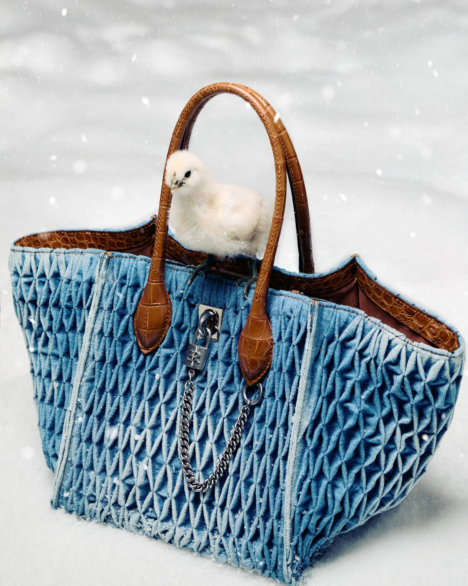 Borsa in pelle trapuntata blu con pulcino su set innevato
